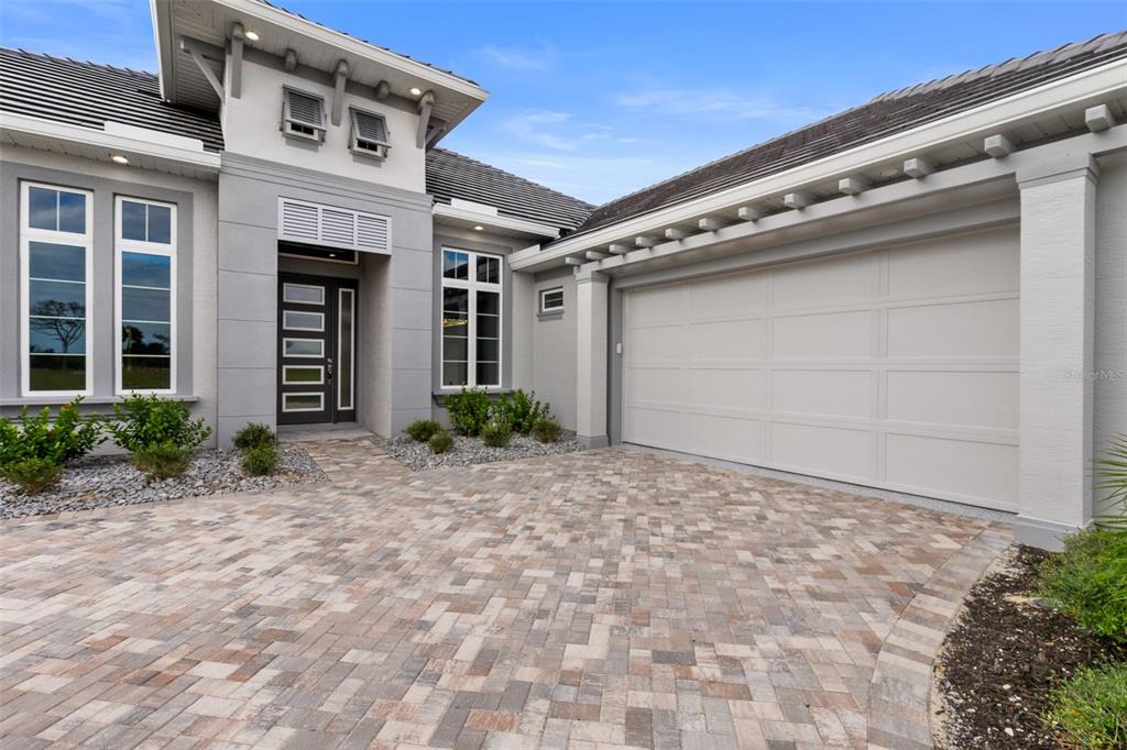 A modern house exterior features a paved driveway, a two-car garage, and a front entrance — 29 CORONADO ROAD, FLAGLER BEACH, FL