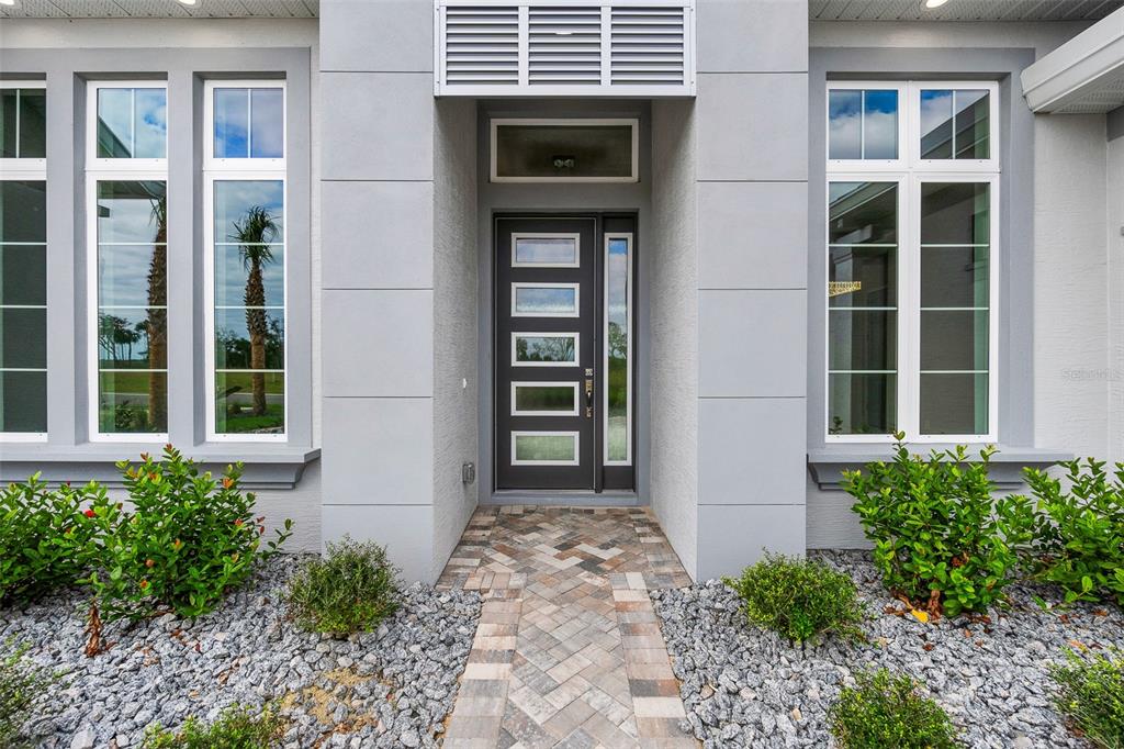The exterior of a modern home features a dark front door with glass panels — 29 CORONADO ROAD, FLAGLER BEACH, FL