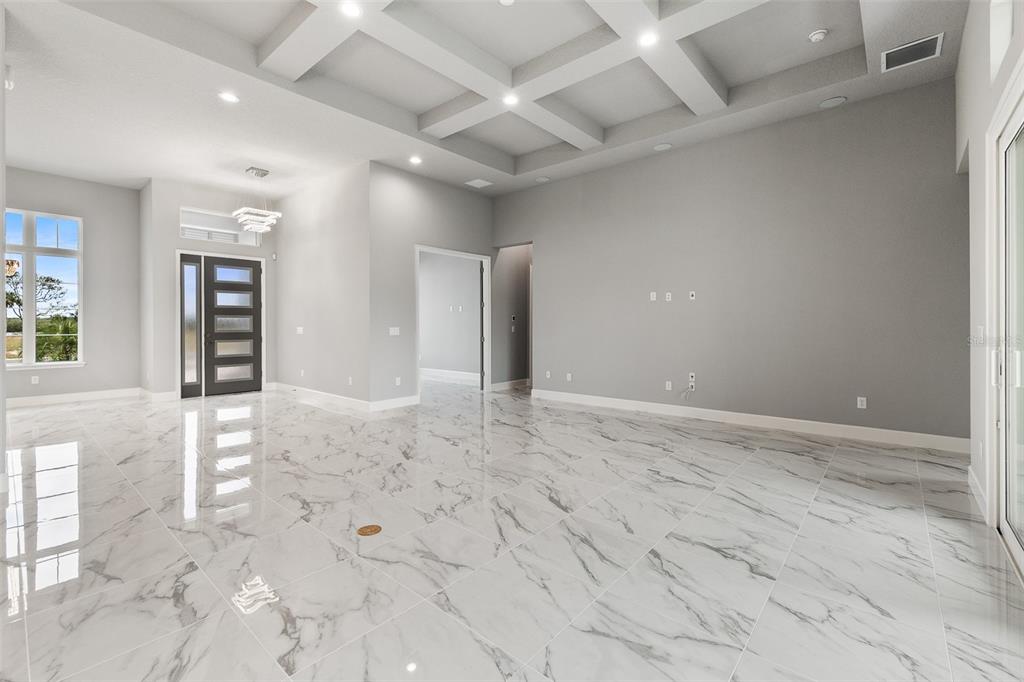 A spacious living room features white marble-look tile floors and a coffered ceiling — 29 CORONADO ROAD, FLAGLER BEACH, FL