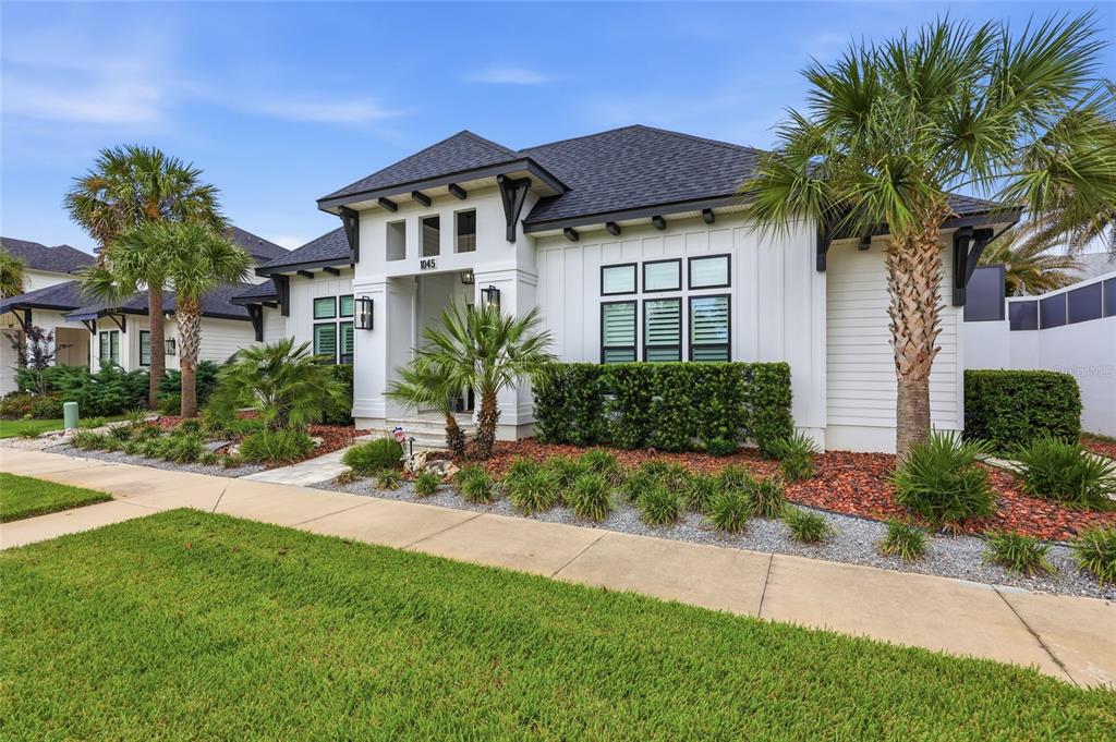 A white single-story house with a dark roof, palm trees, and a landscaped front yard — 1045 SW 132 STREET, NEWBERRY, FL