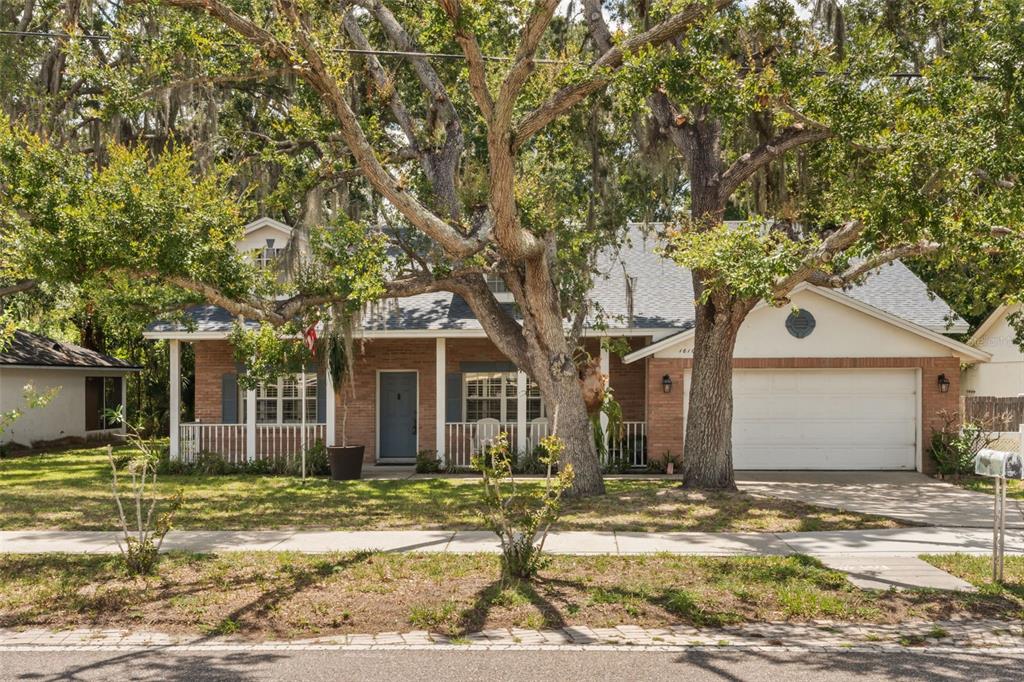 A single-story brick house with a front porch, a two-car garage, and large oak trees — 1610 BEULAH ROAD, WINTER GARDEN, FL