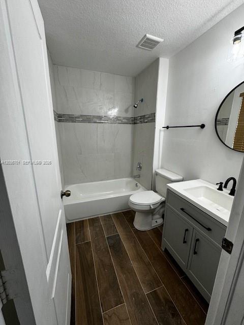 A bathroom features a tub-shower combo, a gray vanity, and wood-look tile flooring — 6970 NW 177th St # M104, Hialeah FL 33015, HIALEAH, FL