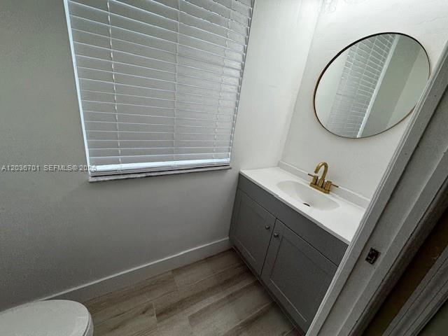 A bathroom features a gray vanity, a round mirror, and a window with white blinds — 6970 NW 177th St # M104, Hialeah FL 33015, HIALEAH, FL