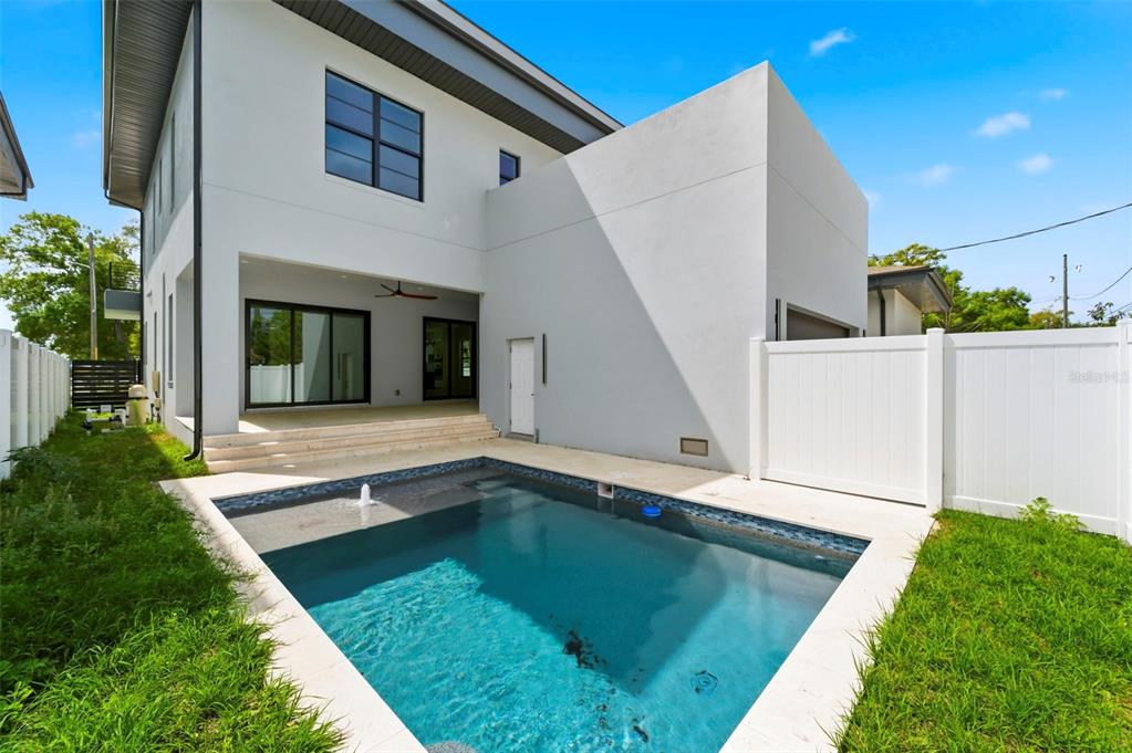 A two-story modern house features a backyard swimming pool and a white vinyl fence — 4543 26TH AVENUE S, ST PETERSBURG, FL