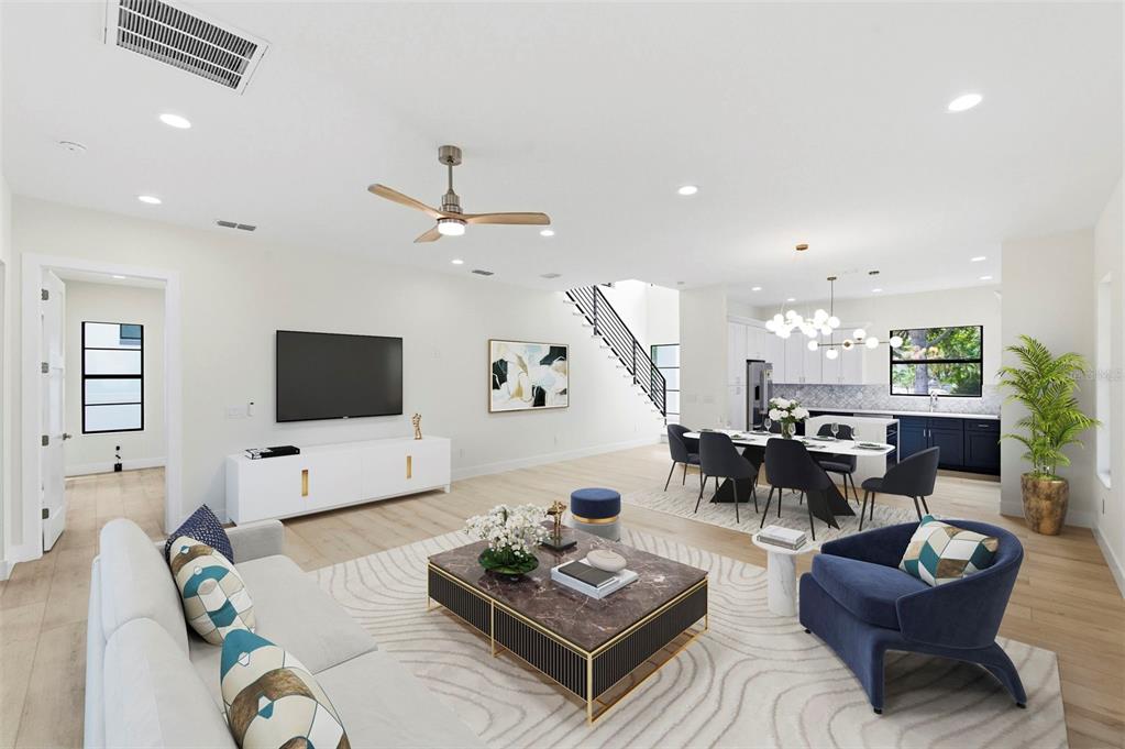 An open-concept living and dining area features light wood floors, a modern staircase, and furniture — 4543 26TH AVENUE S, ST PETERSBURG, FL