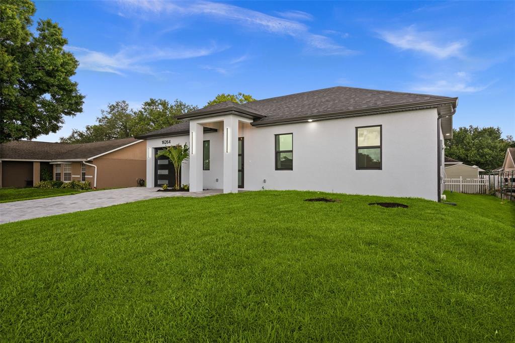 A white, single-story house with a gray roof and a paved driveway sits on grass — 16264 HORIZON ROAD, NORTH FORT MYERS, FL