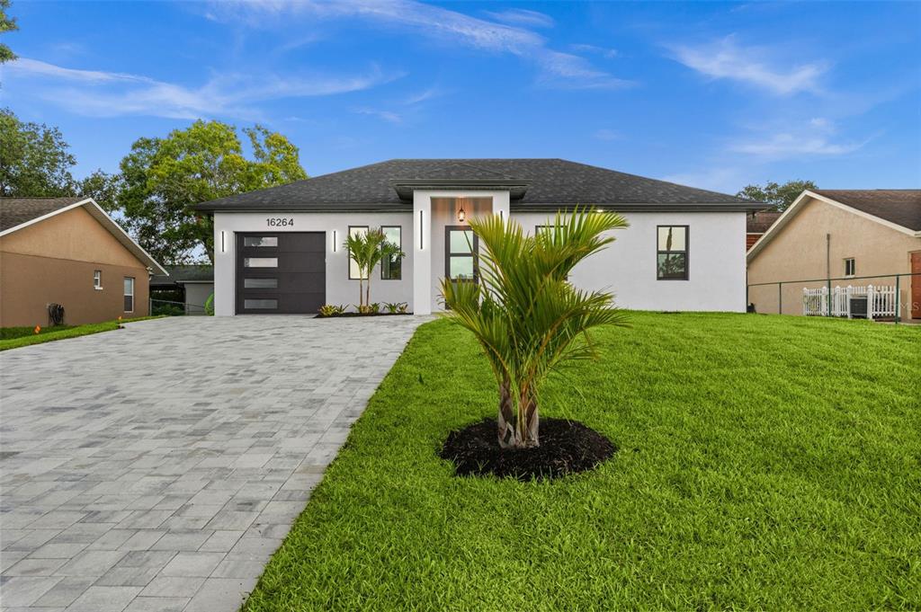 A single-story house with a white exterior, a paved driveway, and a small palm tree — 16264 HORIZON ROAD, NORTH FORT MYERS, FL