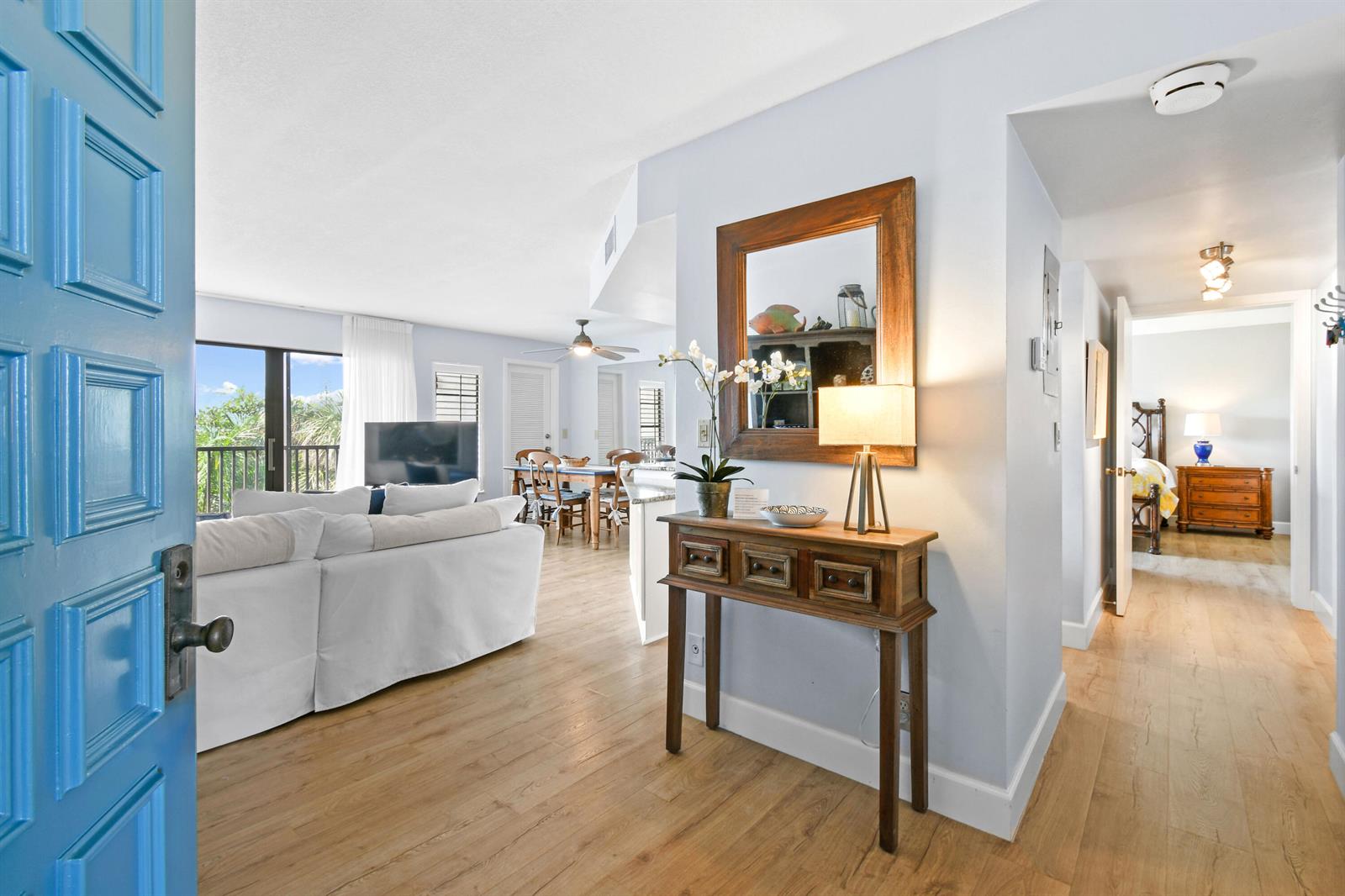 An entryway leads into an open-concept living area with light wood floors and a balcony — 1605 S Us Highway 1 # V6, Jupiter FL 33477, JUPITER, FL