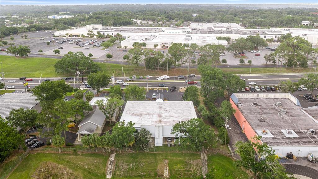 An aerial view shows a commercial building with a flat roof next to a parking lot — 3101 SW COLLEGE ROAD UNIT 200/204, OCALA, FL