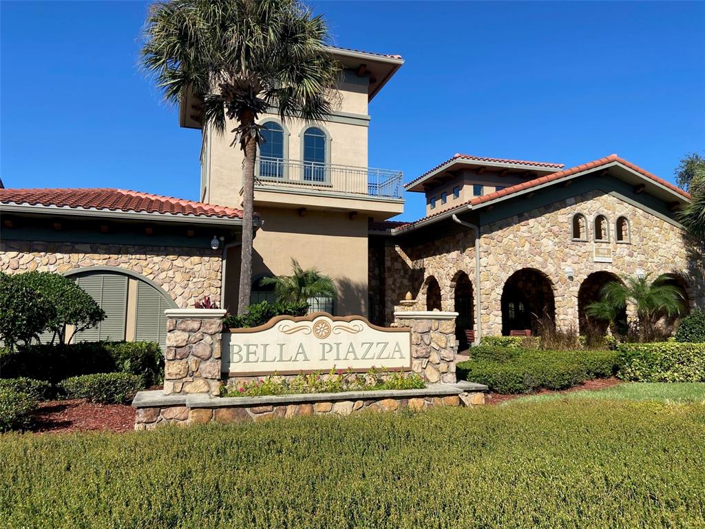 The exterior of a stone-clad building features a prominent sign reading Bella Piazza — 902 CHARO PARKWAY UNIT 622, DAVENPORT, FL