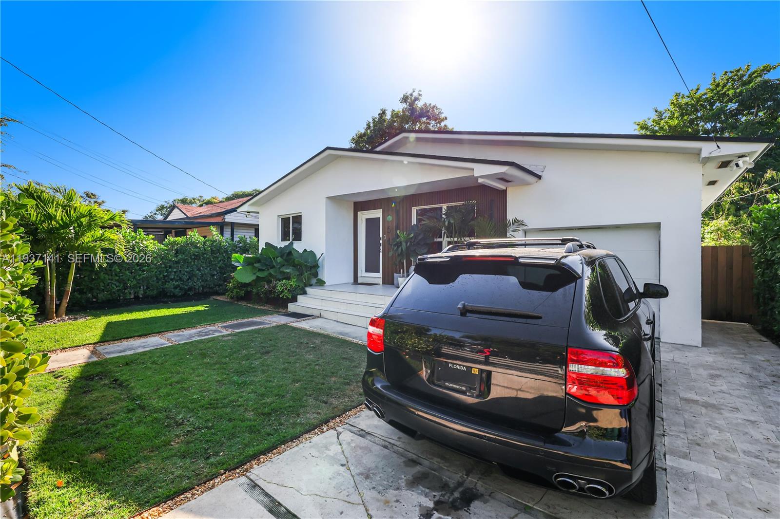 A white house with a black SUV parked in the driveway under a bright sun — 254 NW 43rd St, Miami FL 33127, MIAMI, FL