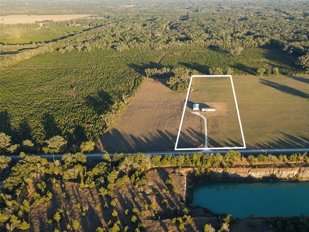 An aerial view shows a house on a rural lot bordered by fields and woods — 3789 NW 202ND STREET, NEWBERRY, FL