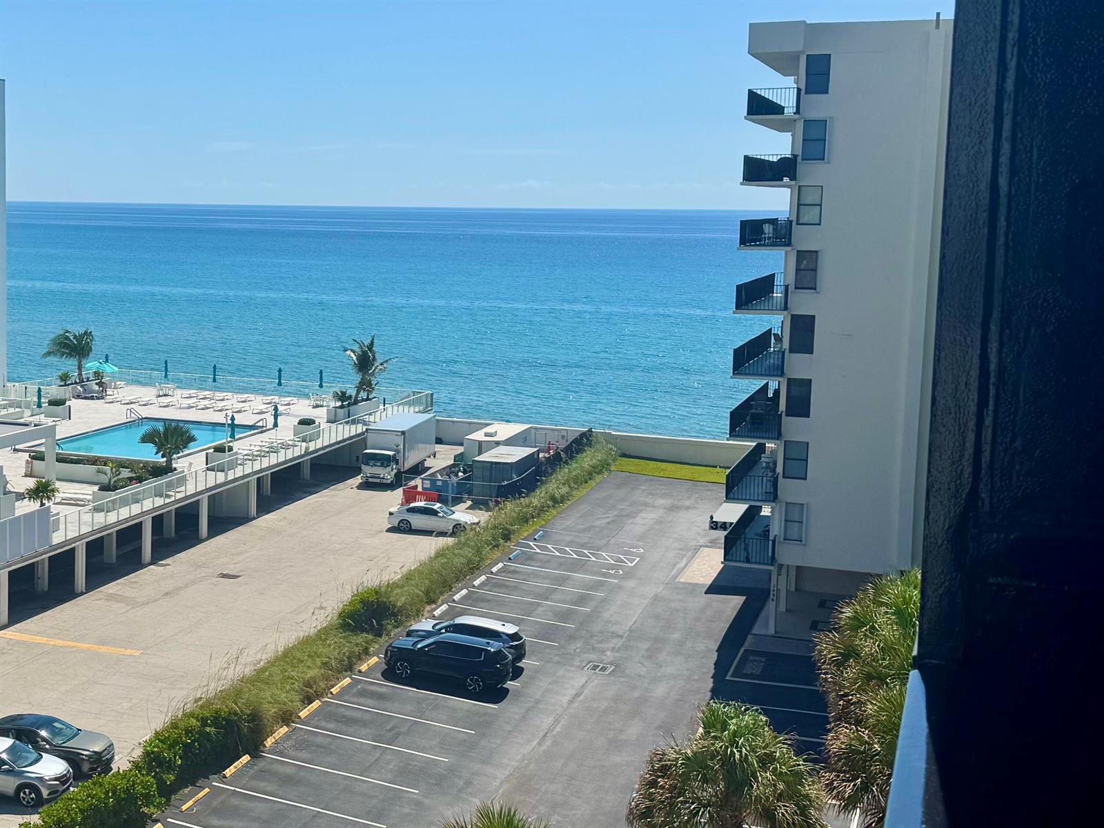 An elevated view shows a parking lot, a swimming pool, and a building beside the ocean — 3460 S Ocean Boulevard # 612, Palm Beach FL 33480, PALM BEACH, FL