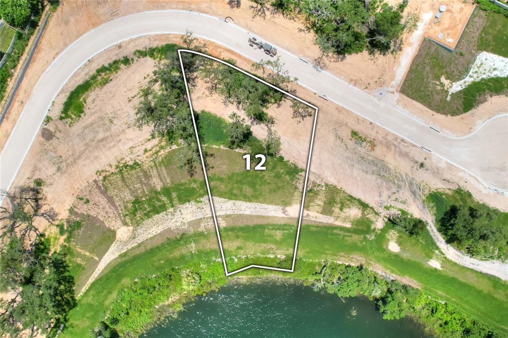 This is an aerial map view of a vacant, trapezoidal residential lot bordering a pond — 149 TRANQUIL MIRROR LAKE COURT Lot 12, CLERMONT, FL