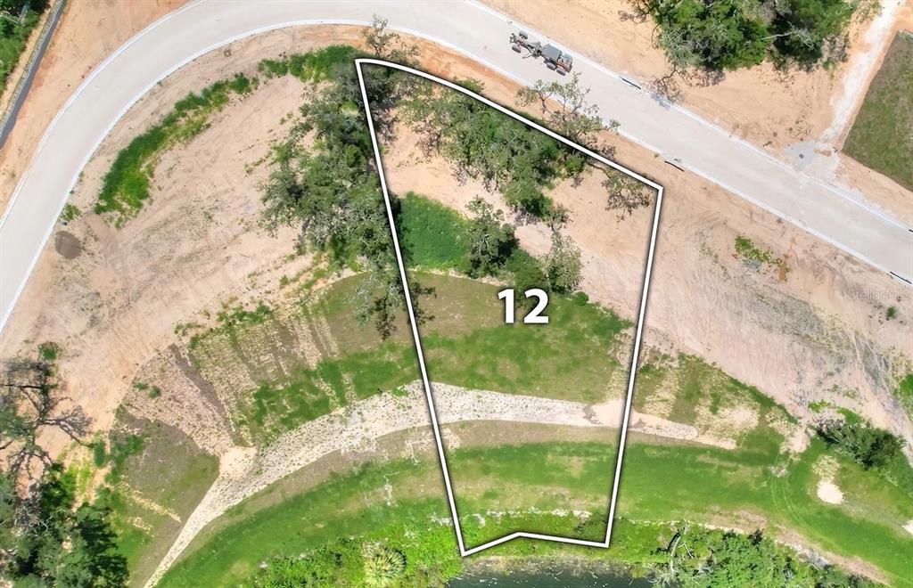 An aerial view shows a vacant, trapezoidal residential lot marked with the number 12 — 149 TRANQUIL MIRROR LAKE COURT Lot 12, CLERMONT, FL