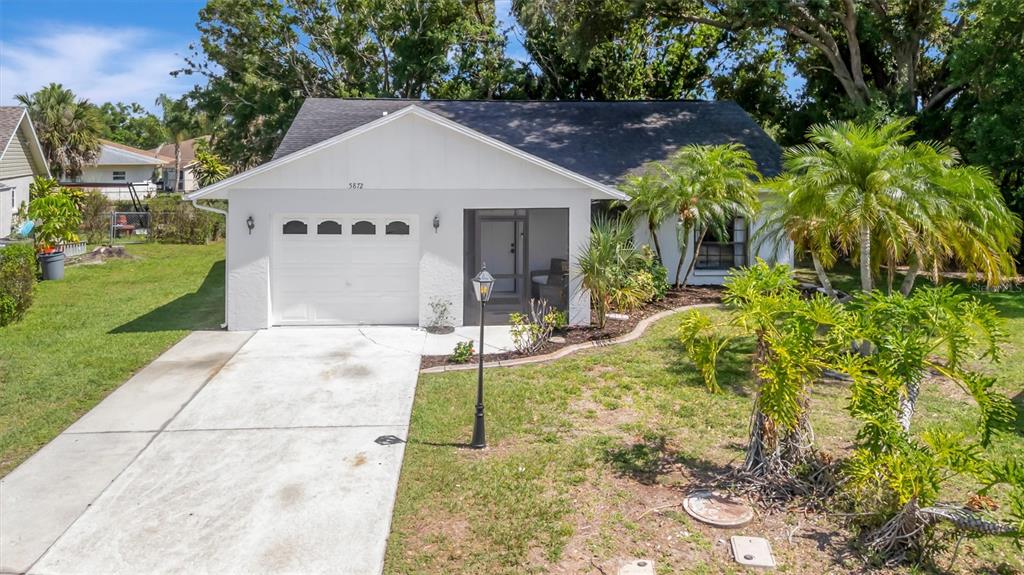 A single-story house with a white exterior, a garage, and a front porch — 5872 PAUMA COURT, SARASOTA, FL