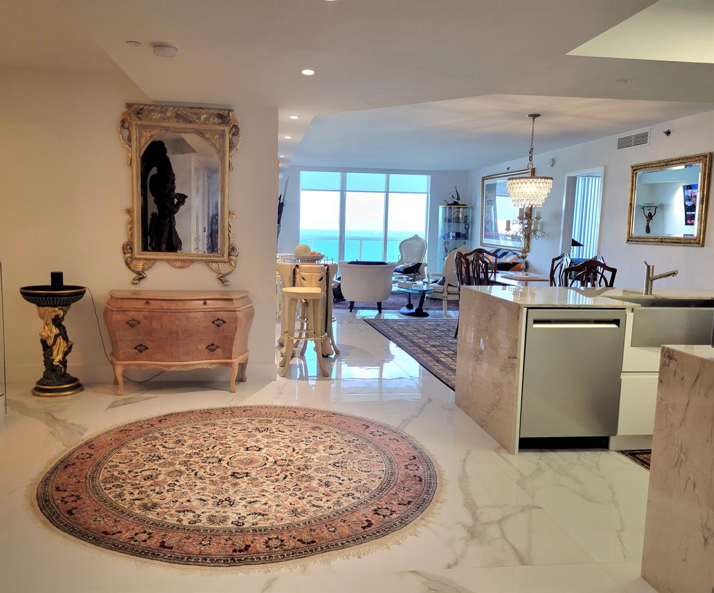 An open-concept living area features marble floors, a kitchen island, and a view of the ocean — 1830 S Ocean Drive # 5111, FL 33009, FL