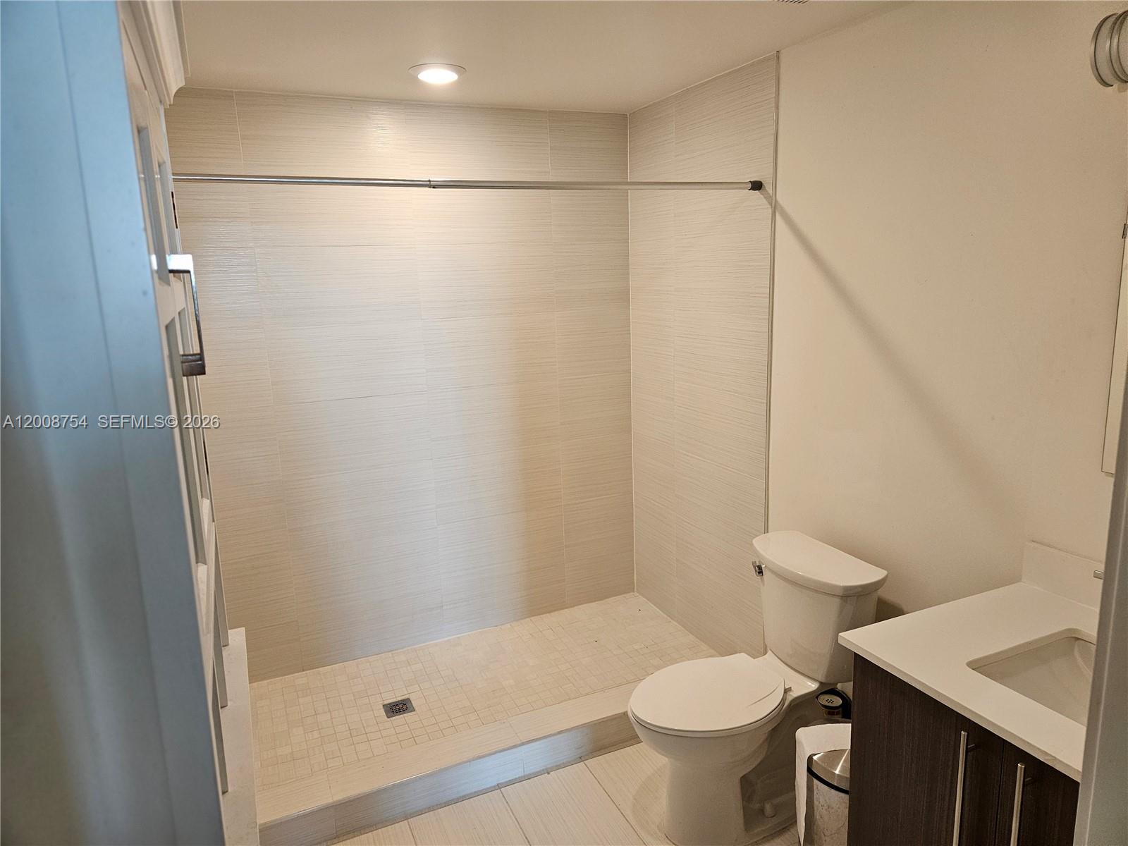 A bathroom features a walk-in shower with light-colored tile, a toilet, and a vanity — 7875 NW 107th Ave # 510, Doral FL 33178, DORAL, FL