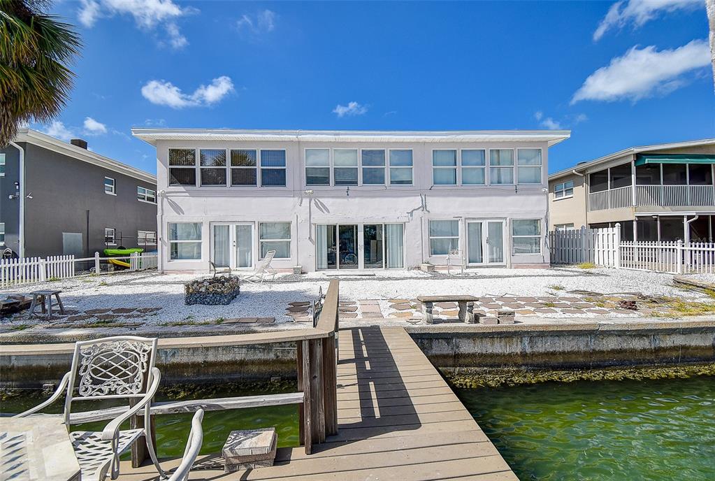 A two-story light purple building with glass block accents and a paved parking lot — 11975 3RD STREET E UNIT 6, TREASURE ISLAND, FL