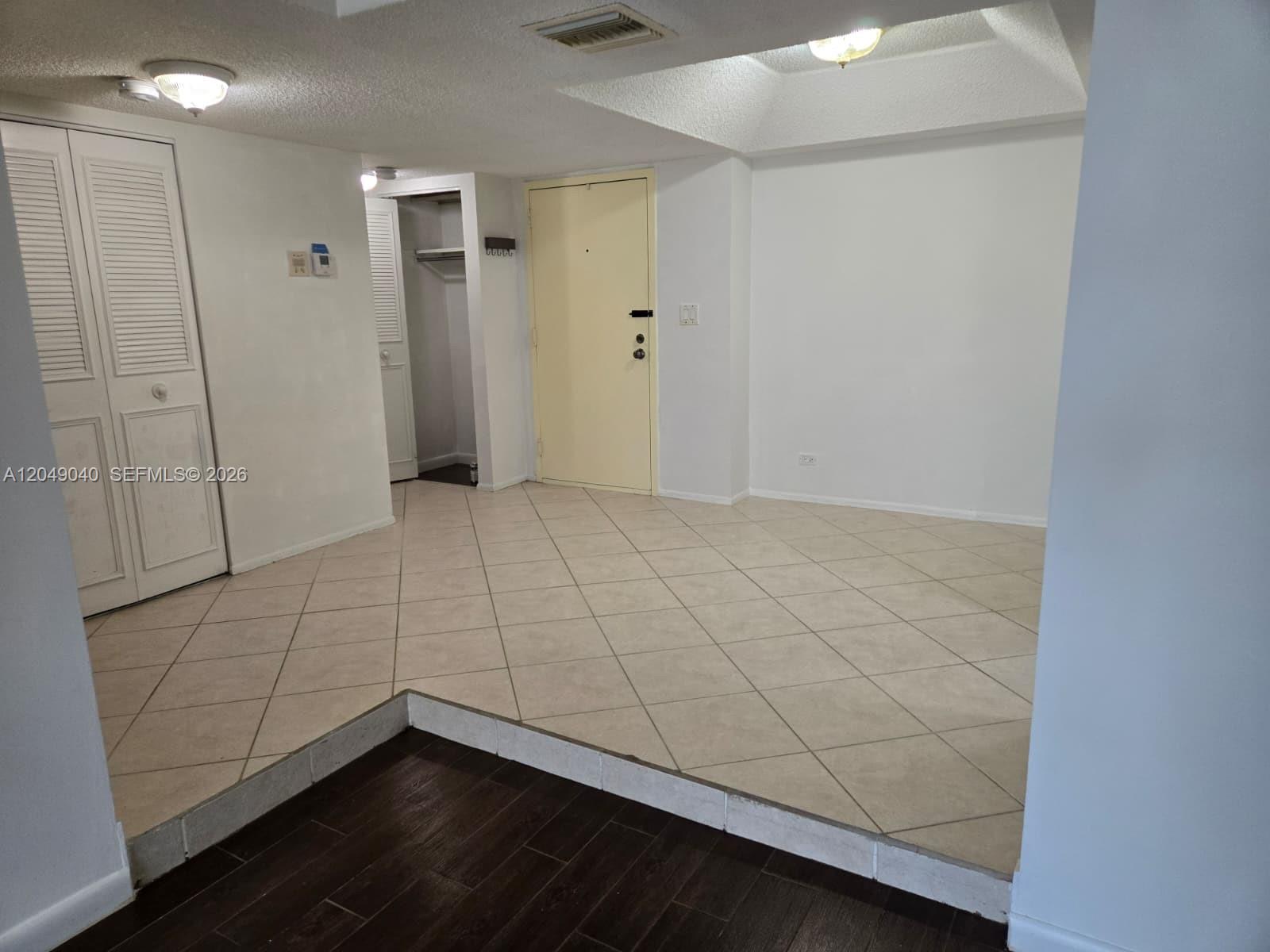 An interior view shows a tiled entryway with a closet and a yellow front door — 3690 Inverrary Dr # 2Q, Lauderhill FL 33319, LAUDERHILL, FL