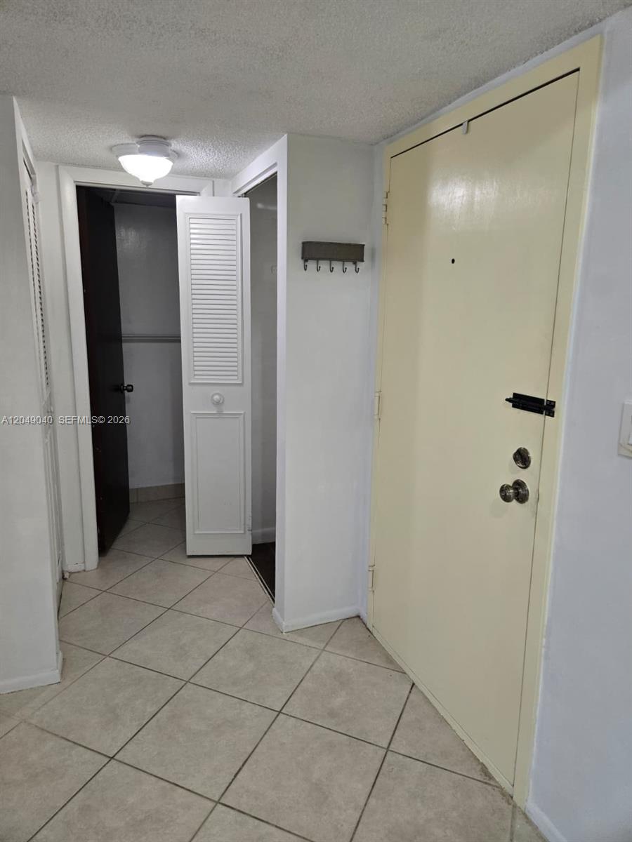 An entryway features a light-colored door, tiled floors, and an open closet door — 3690 Inverrary Dr # 2Q, Lauderhill FL 33319, LAUDERHILL, FL