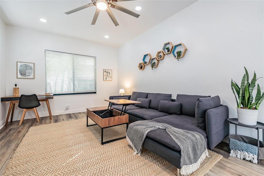 A living room features a gray sectional sofa, a lift-top coffee table, and a desk — 2325 W GREEN STREET, TAMPA, FL