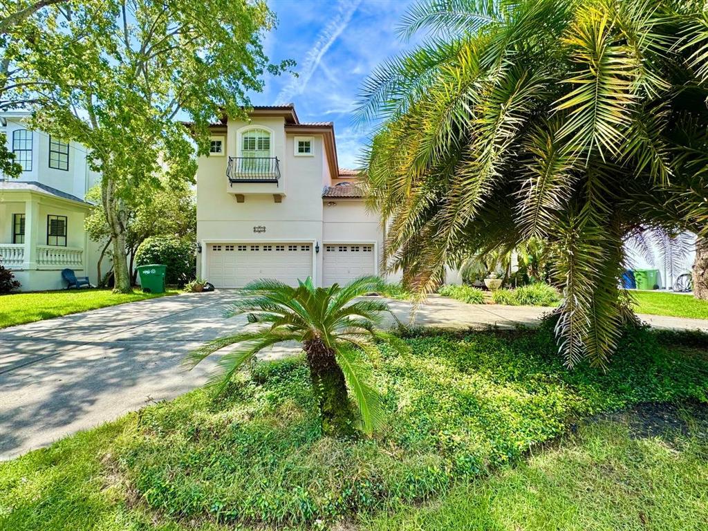 A two-story stucco house with a three-car garage and a balcony sits behind palm trees — 4620 W BROWNING AVENUE, TAMPA, FL
