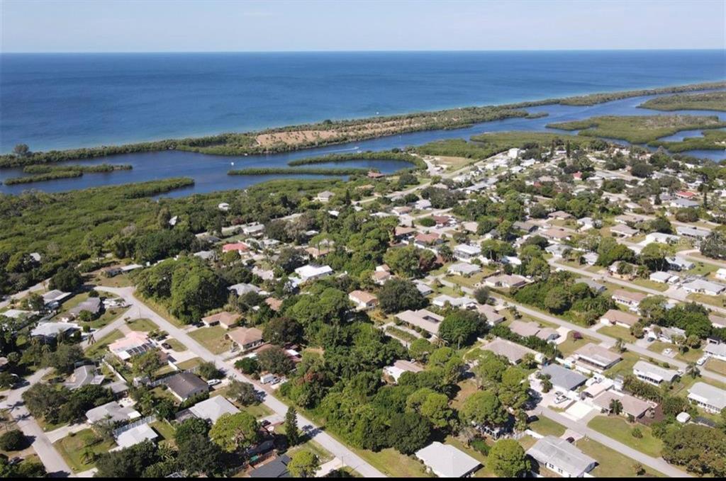An aerial view of a coastal residential neighborhood featuring houses surrounded by trees and water — SOUTHLAND ROAD, VENICE, FL