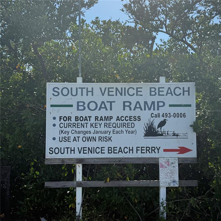 A sign for the South Venice Beach boat ramp and ferry stands among trees — SOUTHLAND ROAD, VENICE, FL