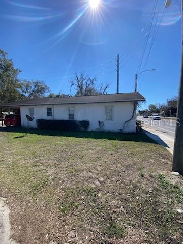 A low-slung, white exterior building sits on a grassy lot next to a paved road — 20371 E MCKINNEY AVENUE, DUNNELLON, FL