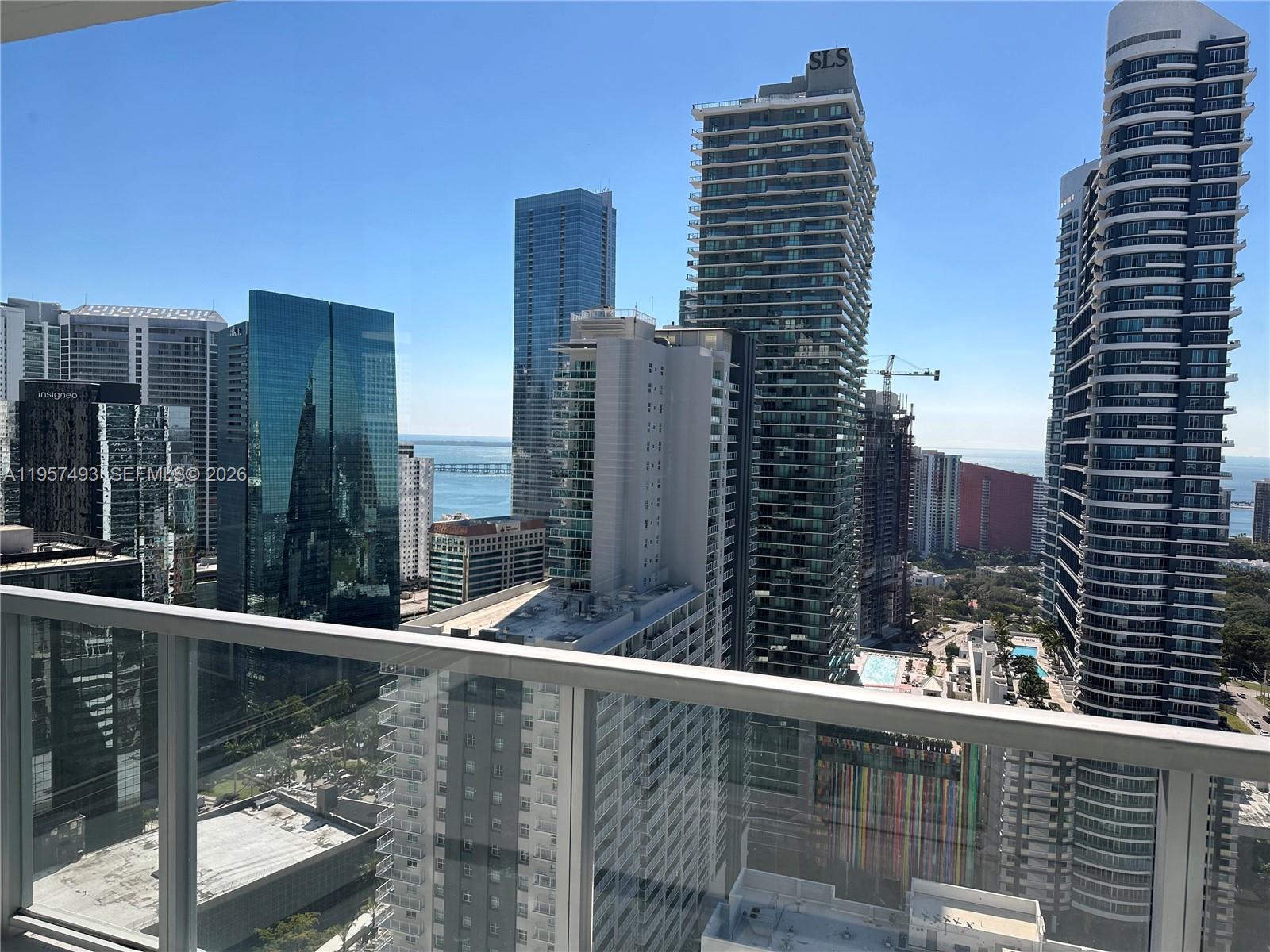 A high-rise balcony view overlooks a dense urban skyline with multiple skyscrapers and the ocean — 1111 SW 1st Ave, Miami FL 33130, MIAMI, FL