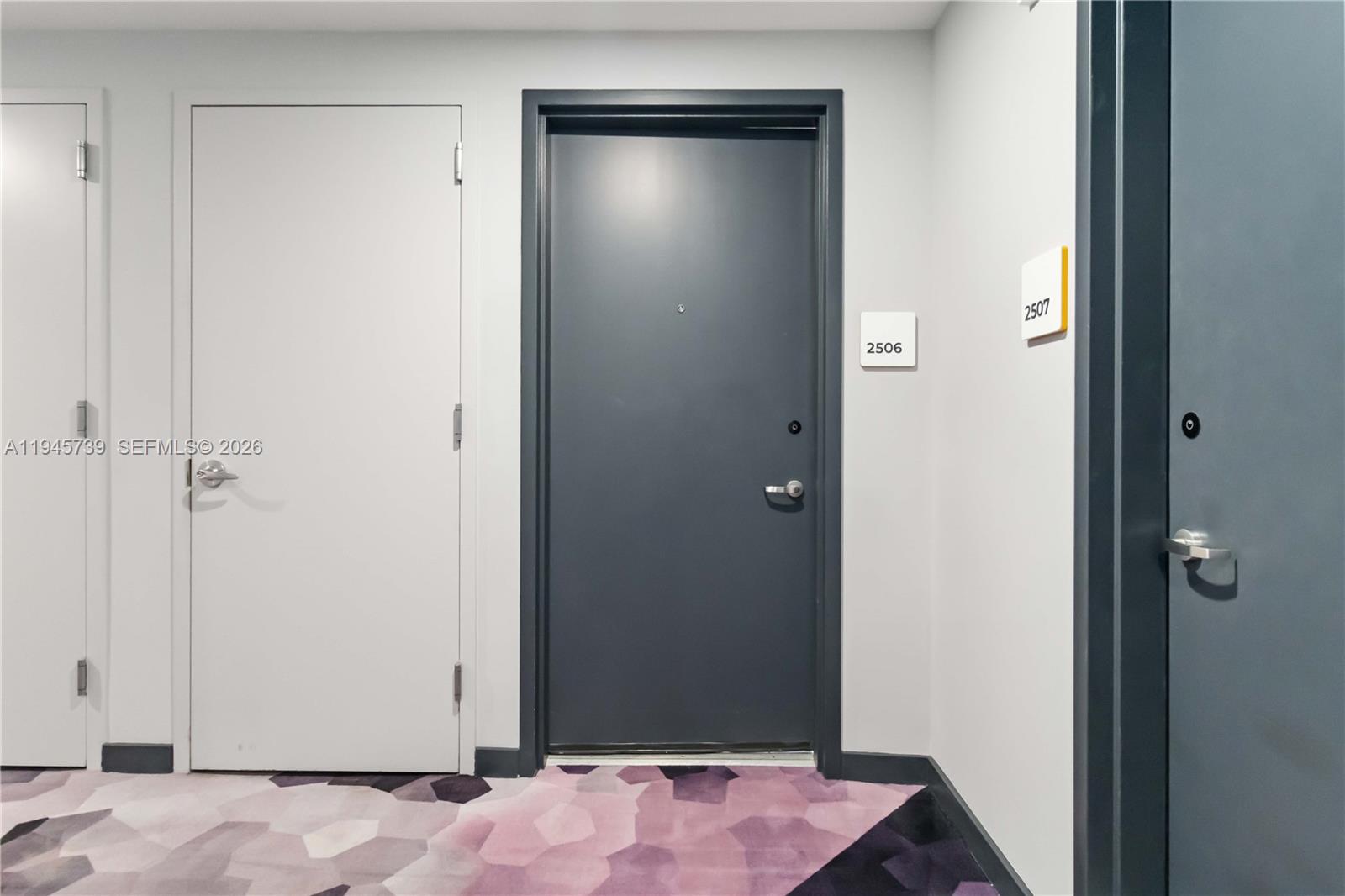 A hallway features three doors, including two dark gray doors labeled 2506 and 2507 — 227 NE 2nd St # 2506, Miami FL 33132, MIAMI, FL