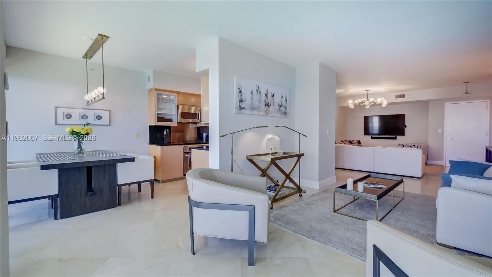 An open-concept living and dining area features light tile floors, modern furniture, and a kitchen — 6365 Collins Ave # 3802, Miami Beach FL 33141, MIAMI BEACH, FL