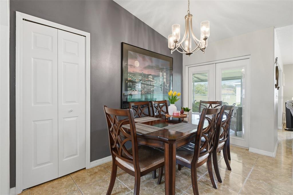 A dining room with a dark accent wall, wooden table, chairs, and a chandelier — 1029 DUDLEY DRIVE, KISSIMMEE, FL
