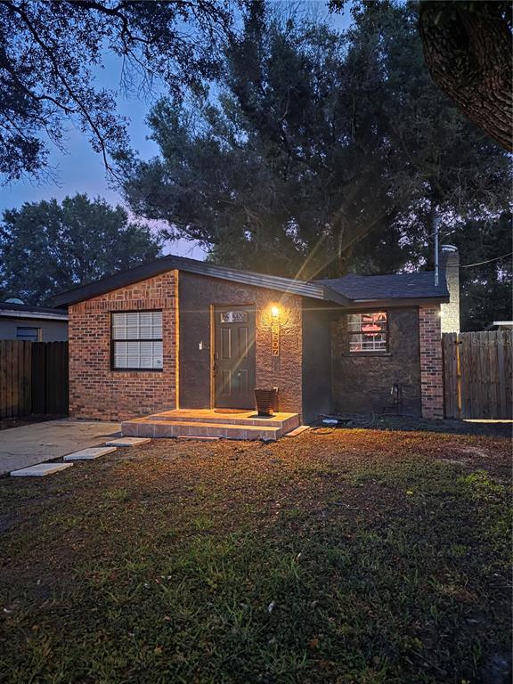 A single-story house with a brick and stucco exterior at dusk — 4607 N 35TH STREET, TAMPA, FL