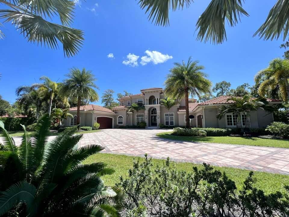 A large two-story house with a tile roof and a paved driveway surrounded by palm trees — 13550 Greentree Trail, Wellington FL 33414, WELLINGTON, FL