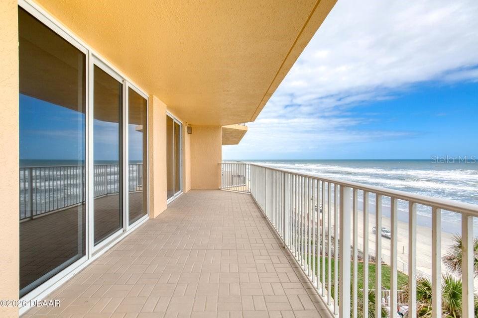 A tiled balcony overlooks the ocean with a white metal railing and sliding glass doors — 3145 S ATLANTIC AVENUE UNIT 503, DAYTONA BEACH, FL