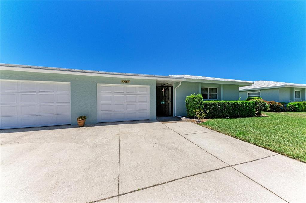 A single-story house with a two-car garage, concrete driveway, and a manicured front lawn — 6905 9TH AVENUE W UNIT 6905, BRADENTON, FL