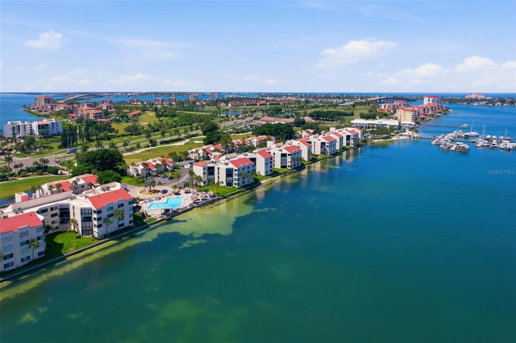 An aerial view shows waterfront apartment buildings with red roofs and a swimming pool — 5729 PUERTA DEL SOL BOULEVARD S UNIT 186, ST PETERSBURG, FL