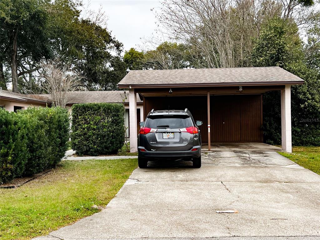 A gray SUV is parked in a covered carport attached to a single-story residential building — 366 DIAMOND STREET, DELTONA, FL