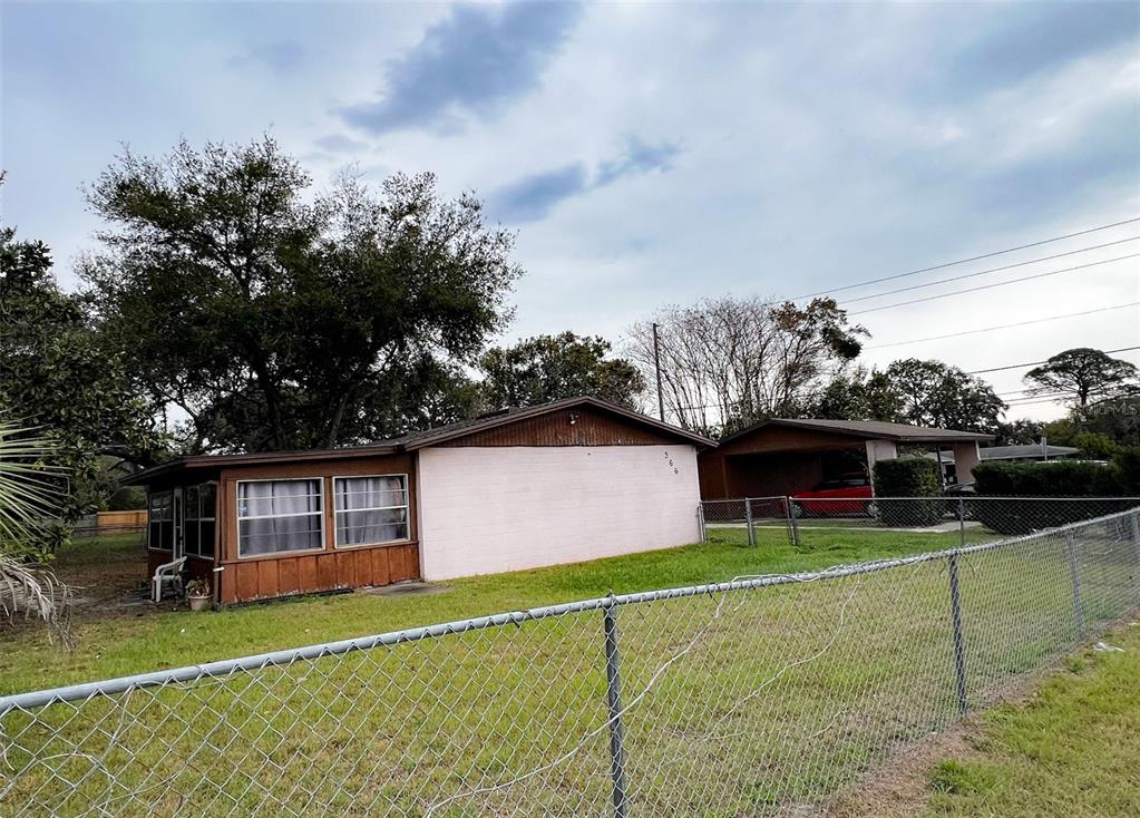 A single-story house with a light-colored exterior, a screened porch, and an attached carport — 366 DIAMOND STREET, DELTONA, FL