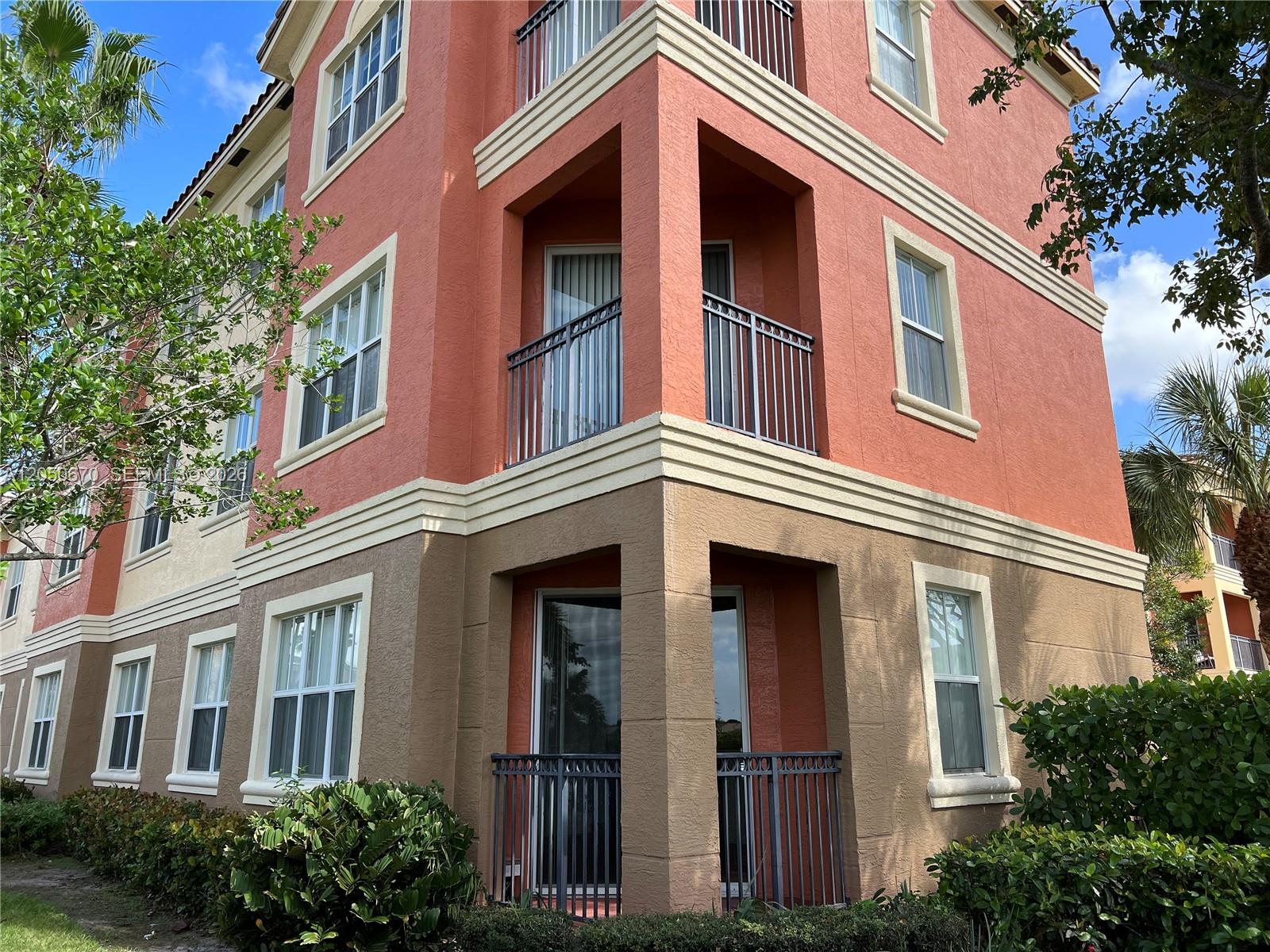 A three-story apartment building features a terracotta and tan stucco exterior with recessed balconies — 4600 SW 160th Ave # 619, Miramar FL 33027, MIRAMAR, FL