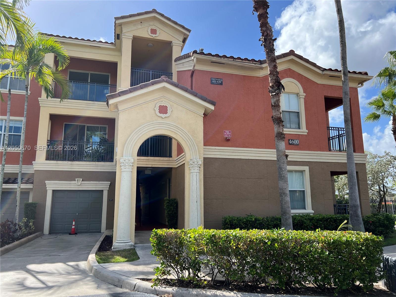 A multi-story apartment building features a stucco exterior, arched entryway, and attached garage — 4600 SW 160th Ave # 619, Miramar FL 33027, MIRAMAR, FL