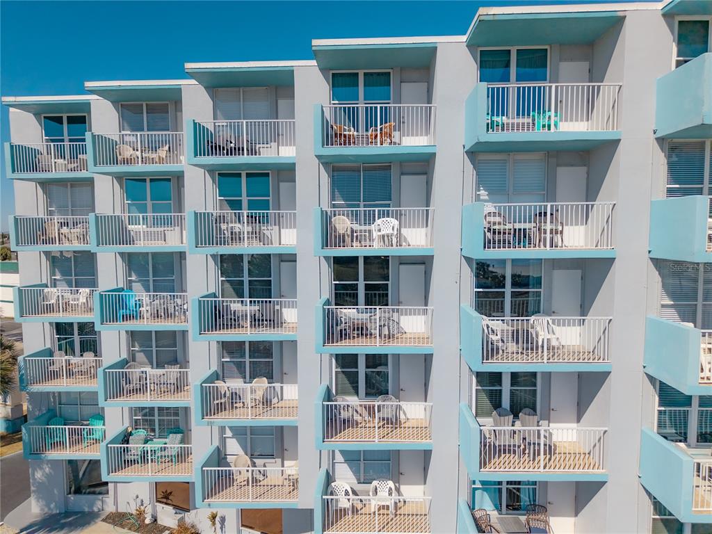 An exterior view of a multi-story apartment building featuring stacked balconies with white railings — 313 S ATLANTIC AVENUE UNIT 4250, DAYTONA BEACH, FL