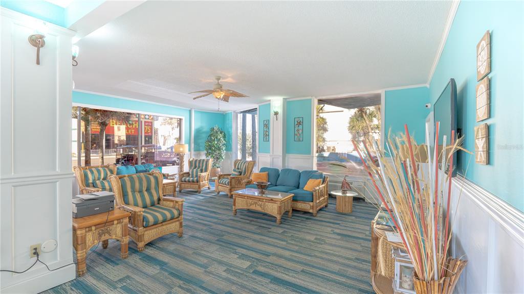 A lobby area features blue walls, wicker furniture, and a blue-patterned carpet — 313 S ATLANTIC AVENUE UNIT 4250, DAYTONA BEACH, FL