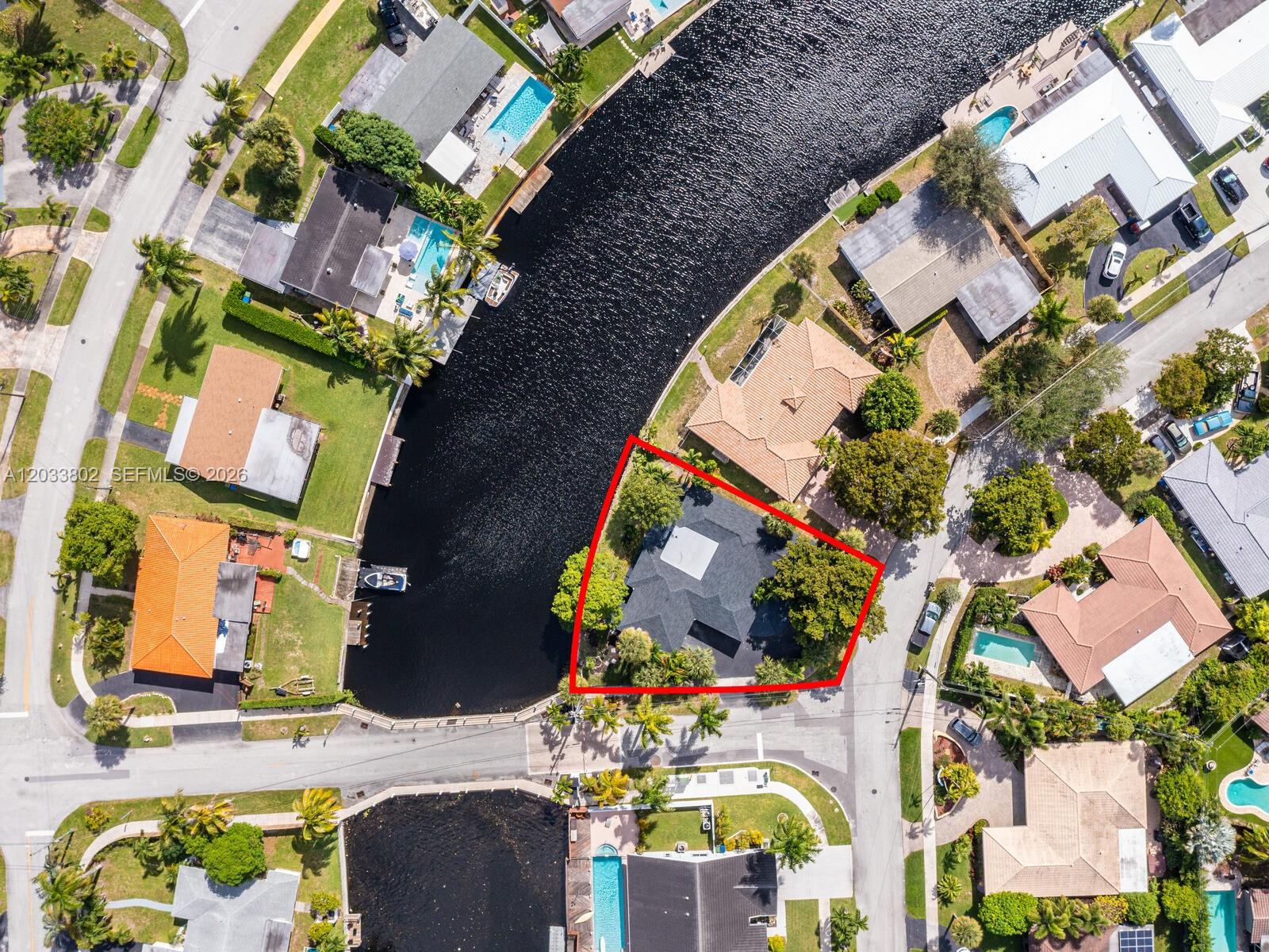 This aerial view shows a residential property with a dark roof located on a canal — 2856 NW 10th Ave, Wilton Manors FL 33311, WILTON MANORS, FL