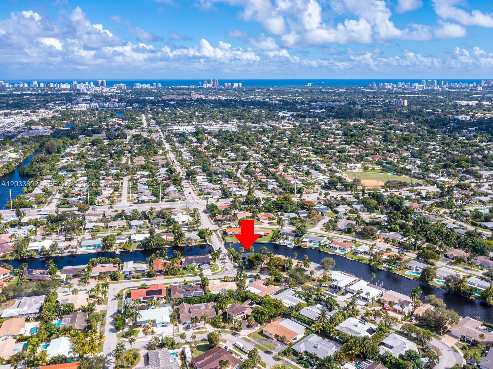 An aerial view shows a residential neighborhood with a canal and a red arrow pointing toward a house — 2856 NW 10th Ave, Wilton Manors FL 33311, WILTON MANORS, FL