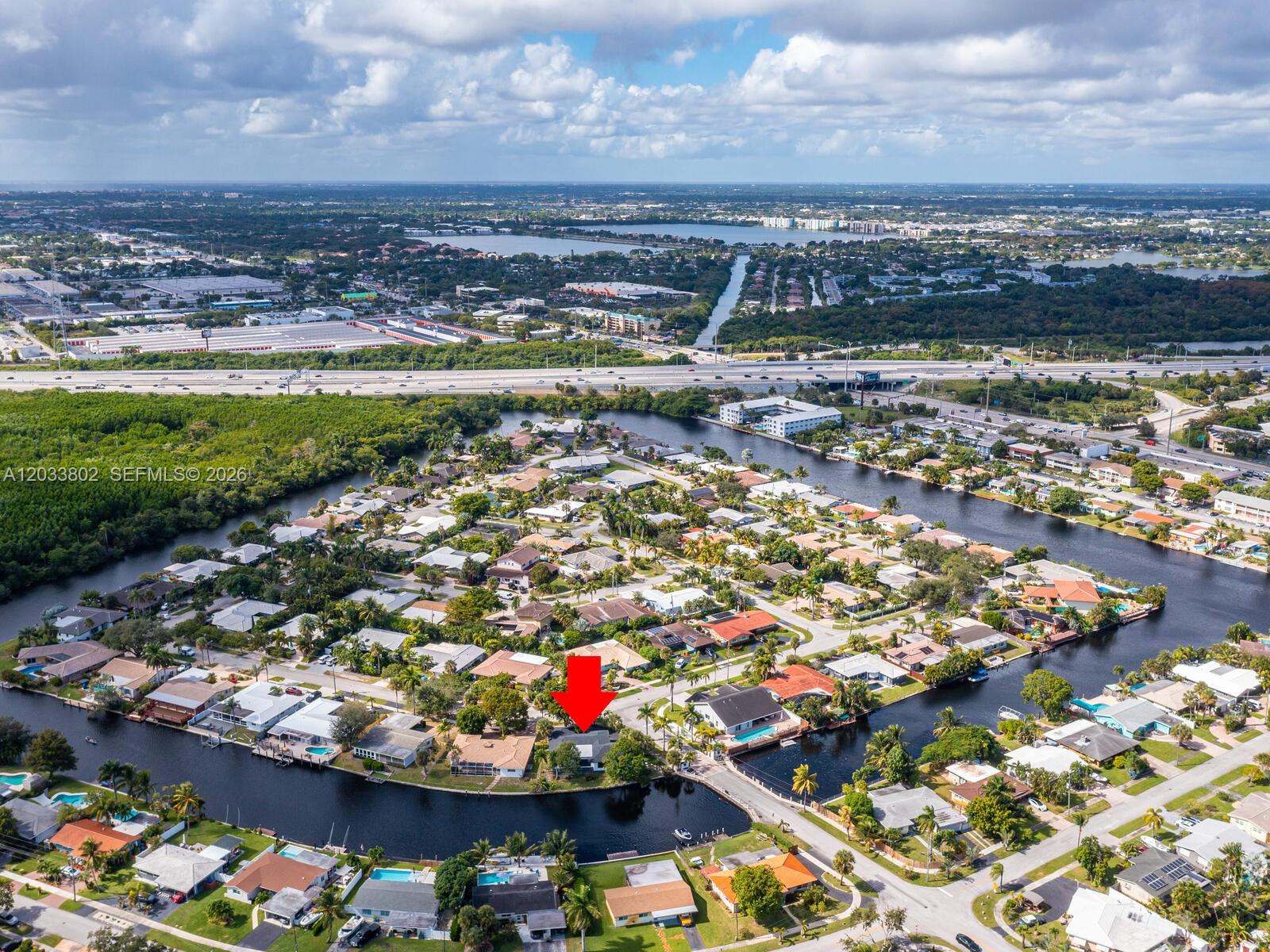 An aerial view shows a residential neighborhood with houses situated along a winding canal — 2856 NW 10th Ave, Wilton Manors FL 33311, WILTON MANORS, FL