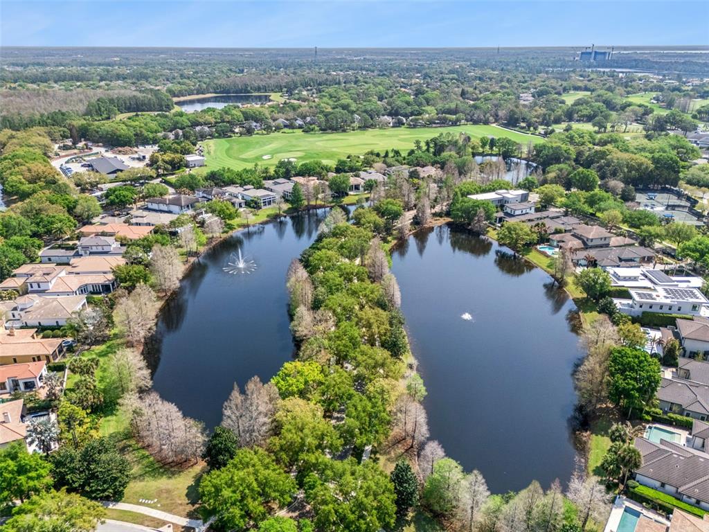 An aerial view shows two ponds surrounded by residential homes and a golf course — 10228 KENSINGTON SHORE DRIVE, ORLANDO, FL