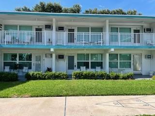A two-story motel building features white railings, sliding glass doors, and a front lawn — 1201 N Riverside Drive # 12b, Pompano Beach FL 33062, POMPANO BEACH, FL